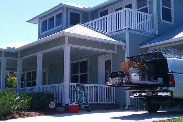 A house with a truck and a ladder for residential painting